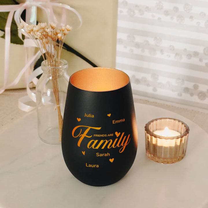 Schwarzes Windlicht „Friends are Family“ mit Namen neben einem Teelicht