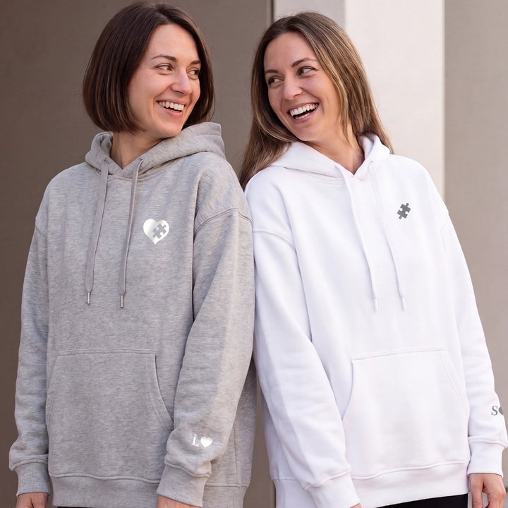 Zwei Freundinnen in grauem und weißem Besties-Hoodie mit Puzzleherz und Puzzlestück