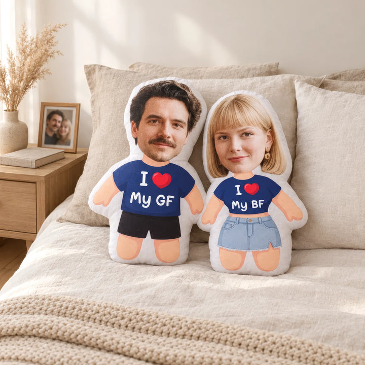 Zwei personalisierte 3D Kissen mit Gesichtern, navyblauen T-Shirts und Schriftzug I ❤ My GF und I ❤ My BF auf einem Bett