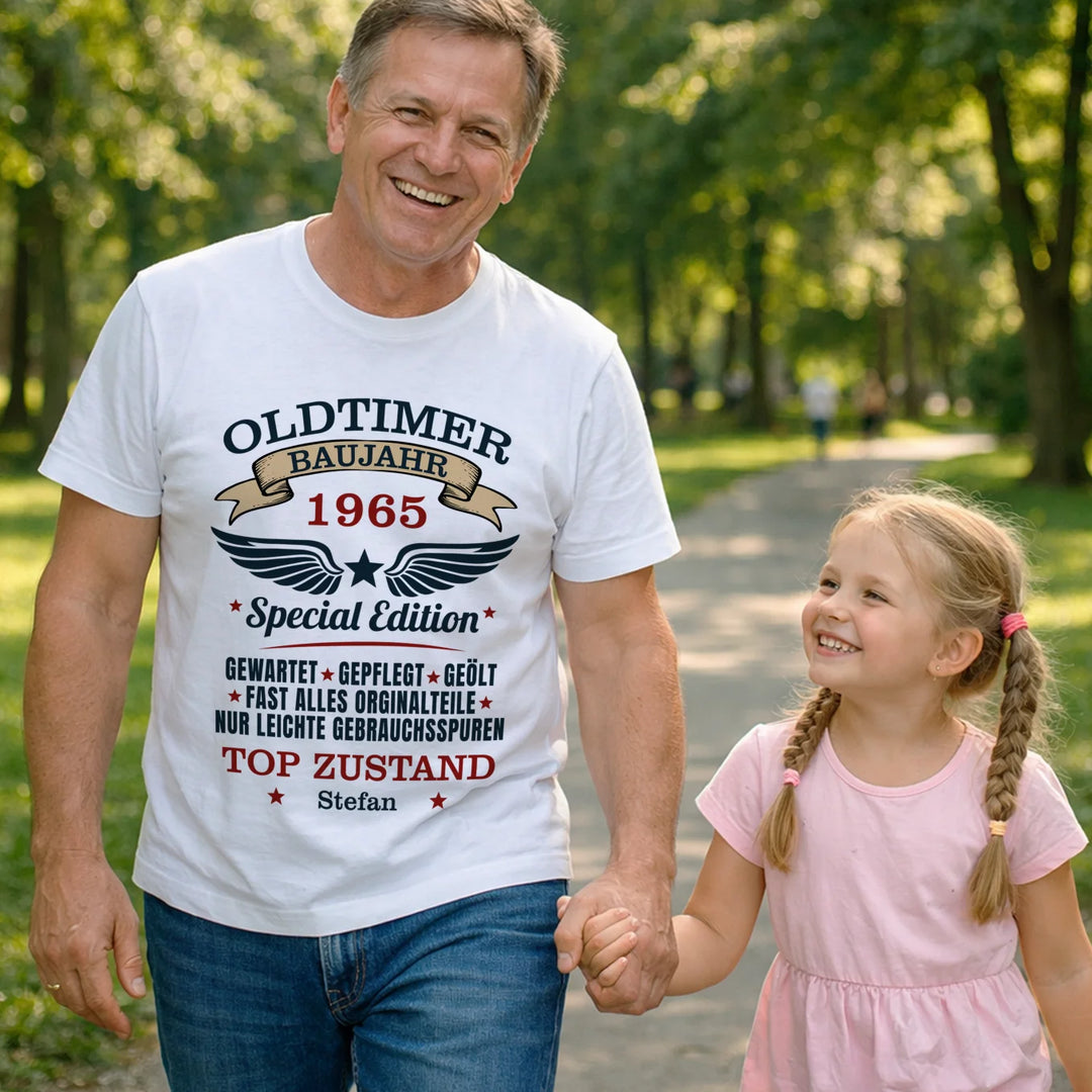 Mann im weißen Oldtimer-T-Shirt geht mit Enkelin im Park spazieren