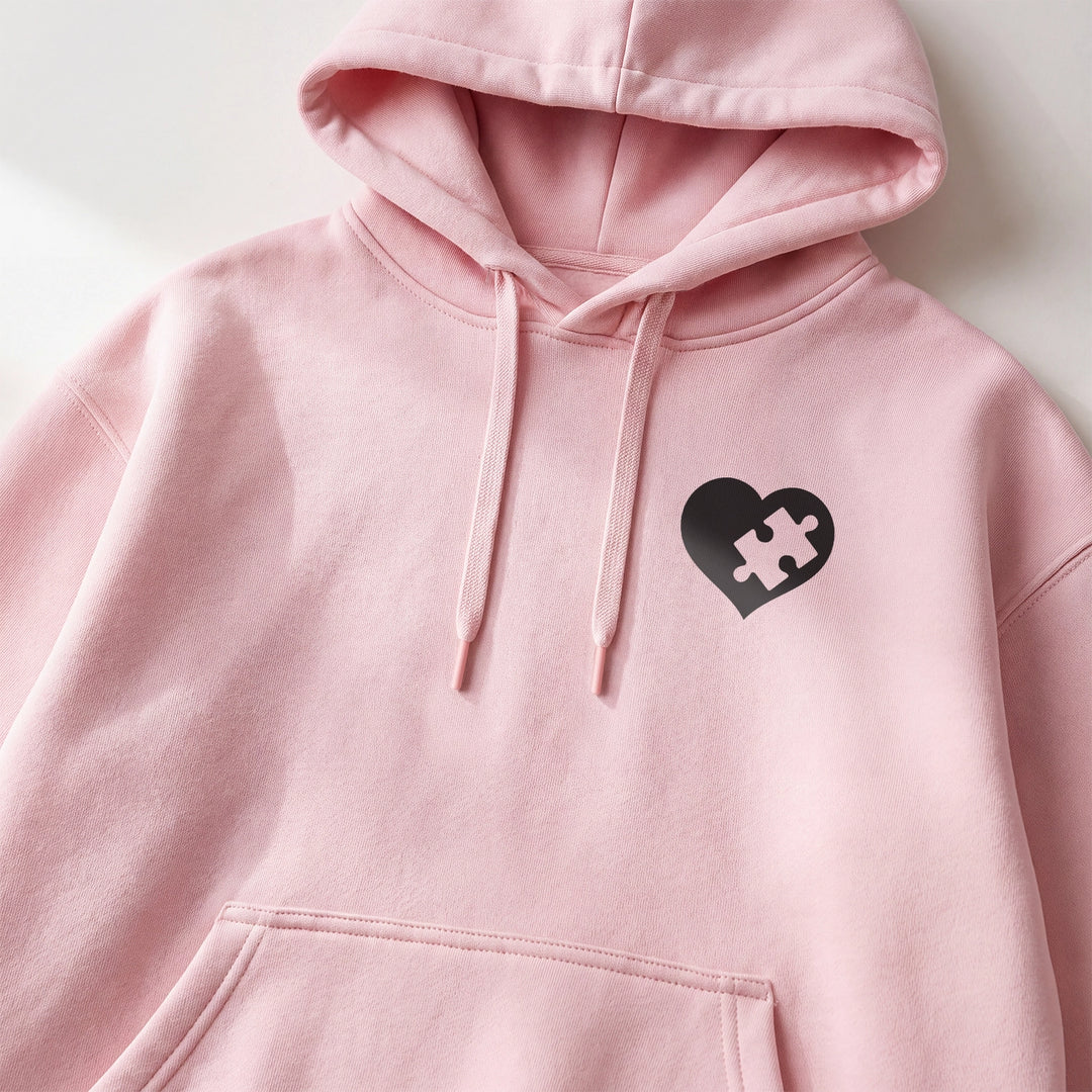 Rosa Hoodie mit schwarzem Puzzleherz auf der Brust