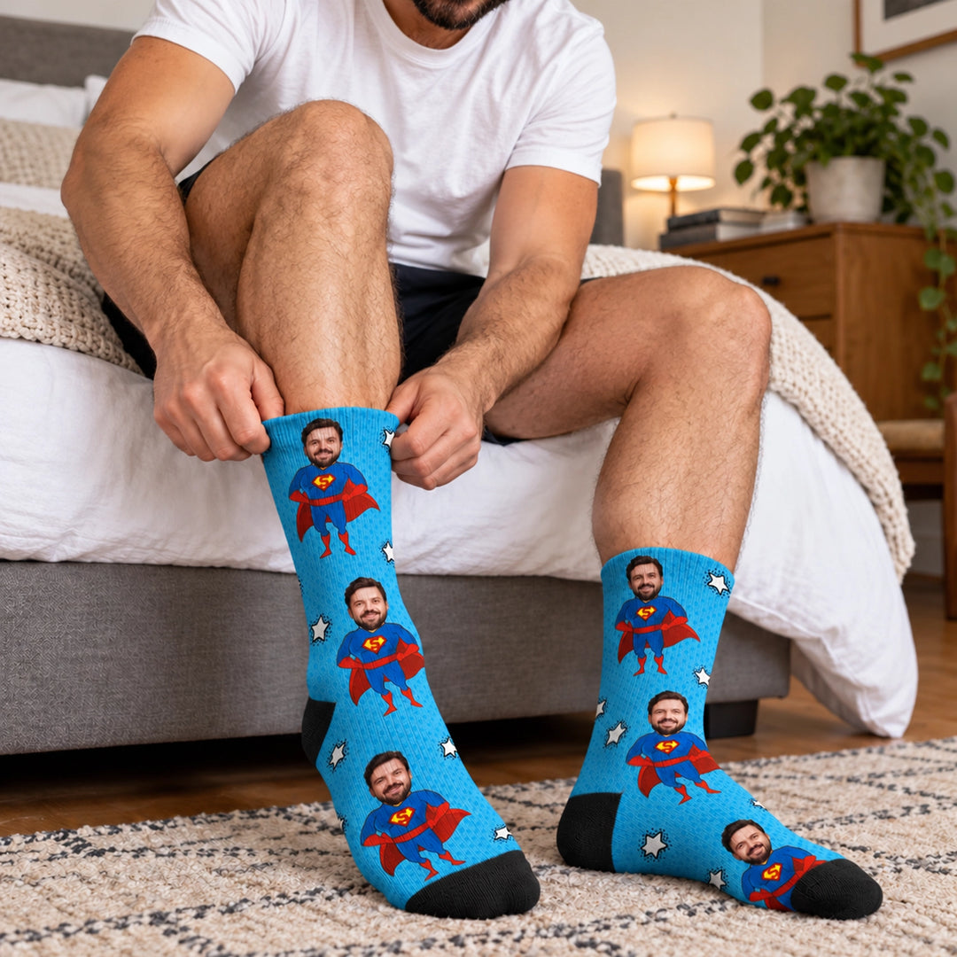 Mann zieht blaue Superheld-Socken mit seinem Gesicht als Comic-Held an