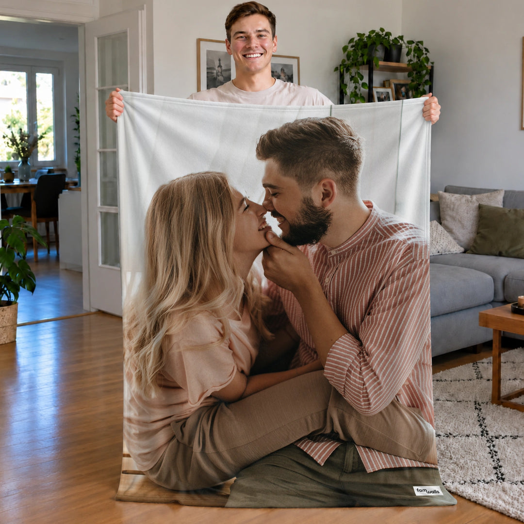 Mann hält die Foto-Decke mit küssendem Paar hoch