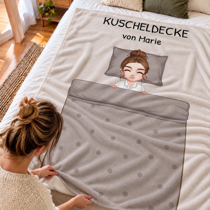 Frau streicht über die graue Cartoon-Decke mit Comicfigur im Bett