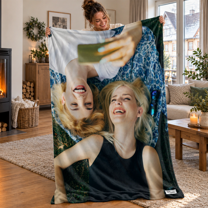Frau hält die Foto-Decke mit lachendem Selfie von zwei Freundinnen hoch