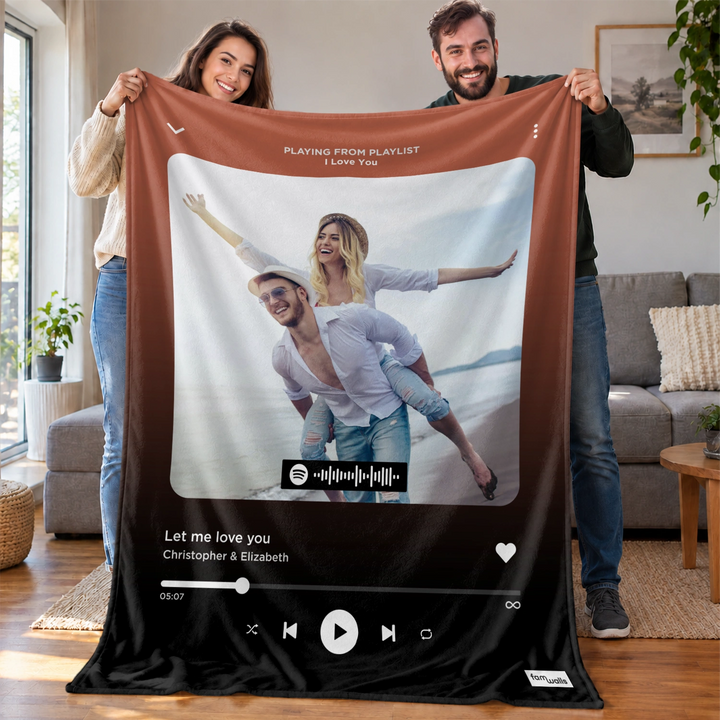 Paar zeigt braune Song-Cover-Decke mit Strandfoto und Spotify-Code