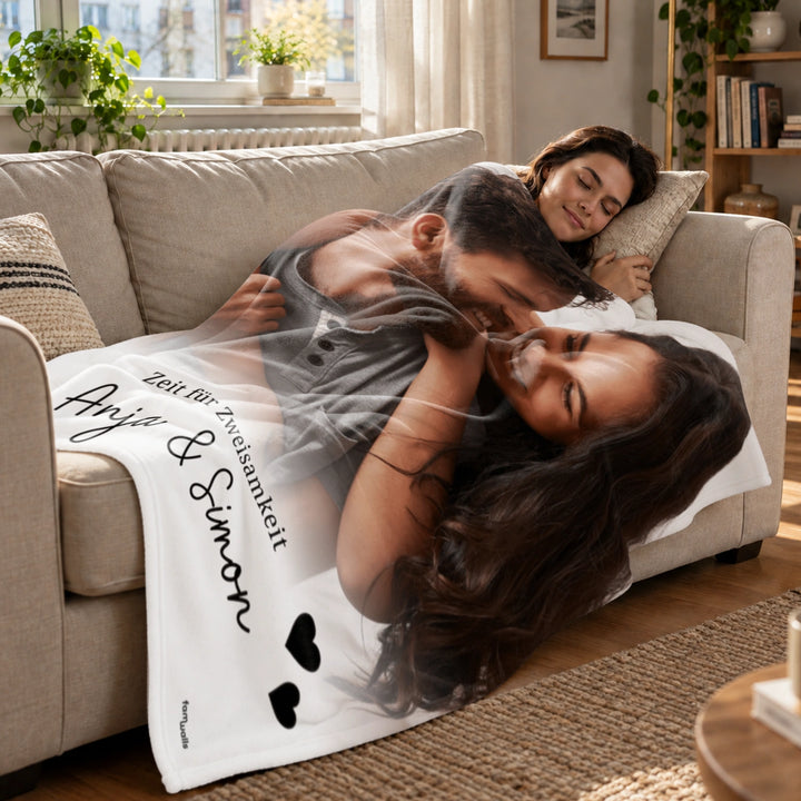 Paar kuschelt auf dem Sofa unter der Fotodecke mit Namen