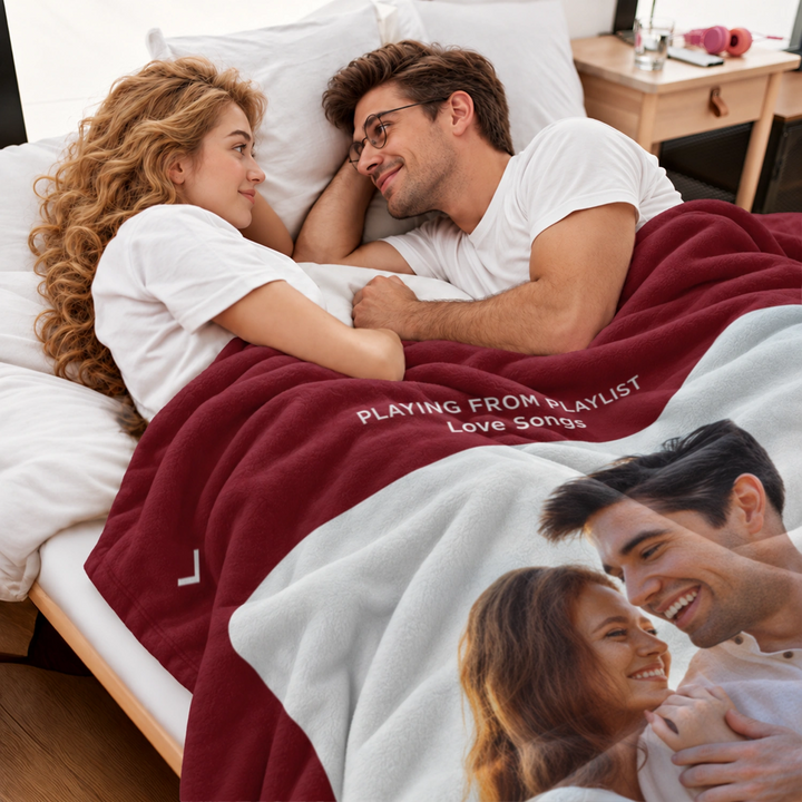 Paar liegt im Bett unter der roten Lieblingslied-Decke mit Paarfoto