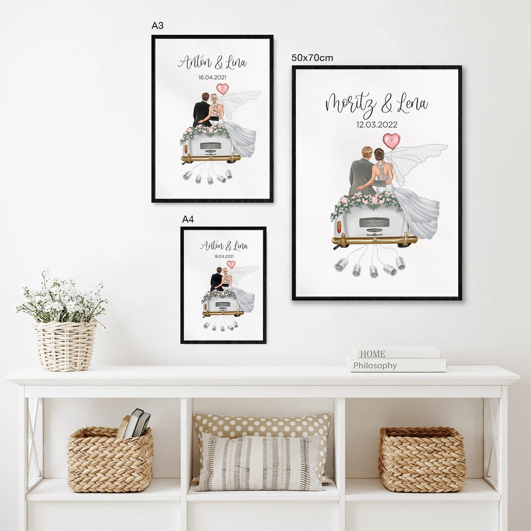 Personalisierte Just Married Poster in verschiedenen Größen, darstellend Brautpaar auf Hochzeitsauto, als Geldgeschenk-Option, über weißem Sideboard mit Deko-Elementen präsentiert